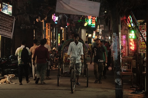 a man riding a bike down a street next to a dog