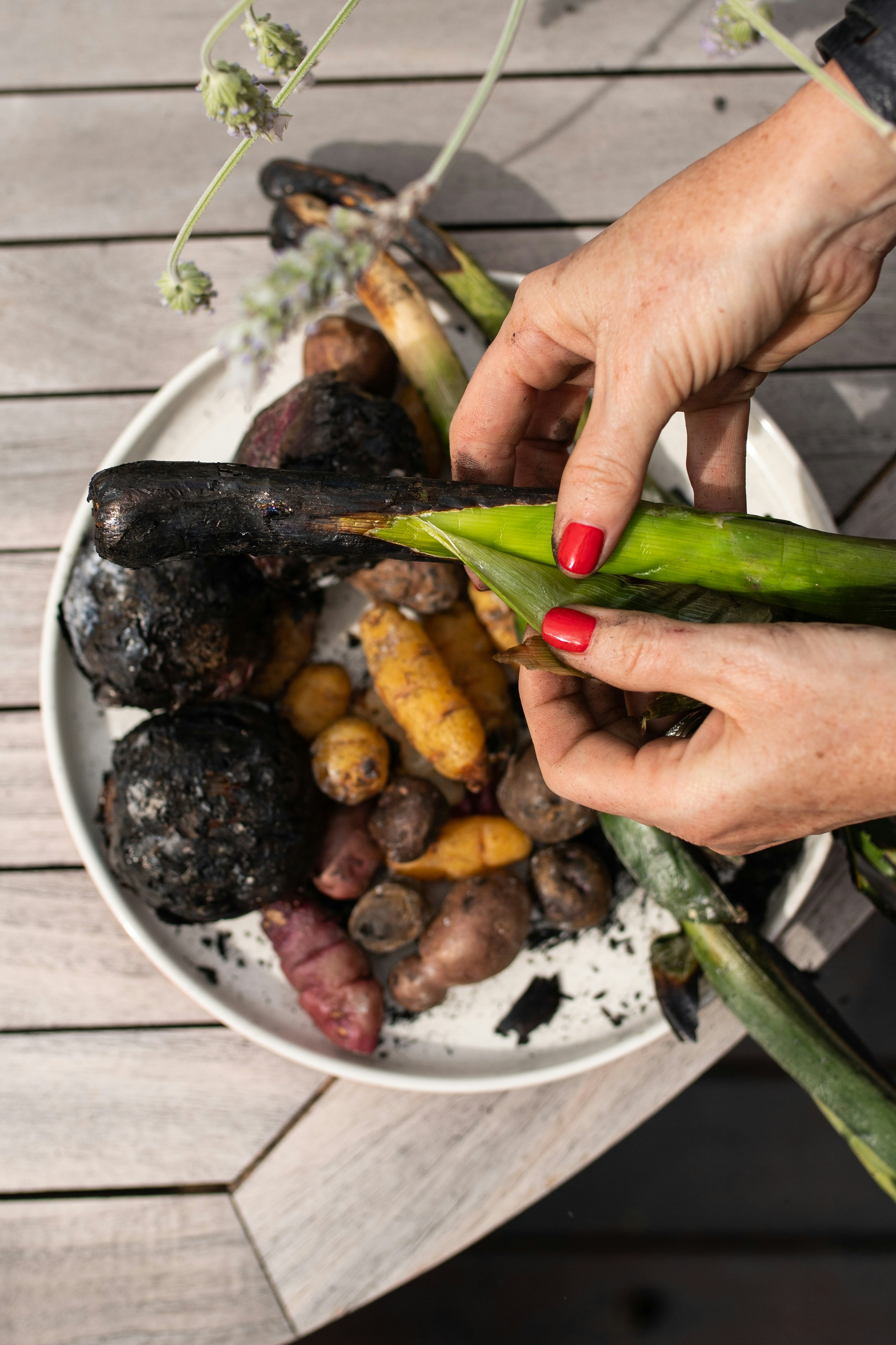Une femme épluche un concombre dans un bol de légumes