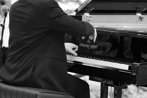 a man in a suit playing a piano