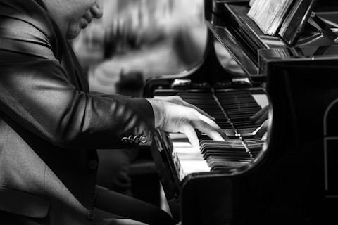 a man in a suit playing a piano