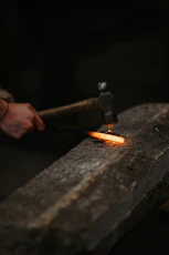 a person holding a metal object with a flame coming out of it