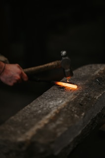 a person holding a metal object with a flame coming out of it