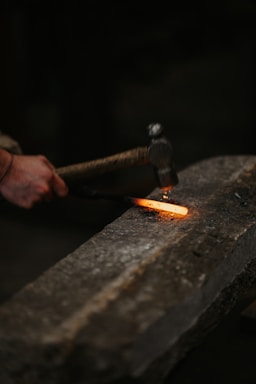 a person holding a metal object with a flame coming out of it