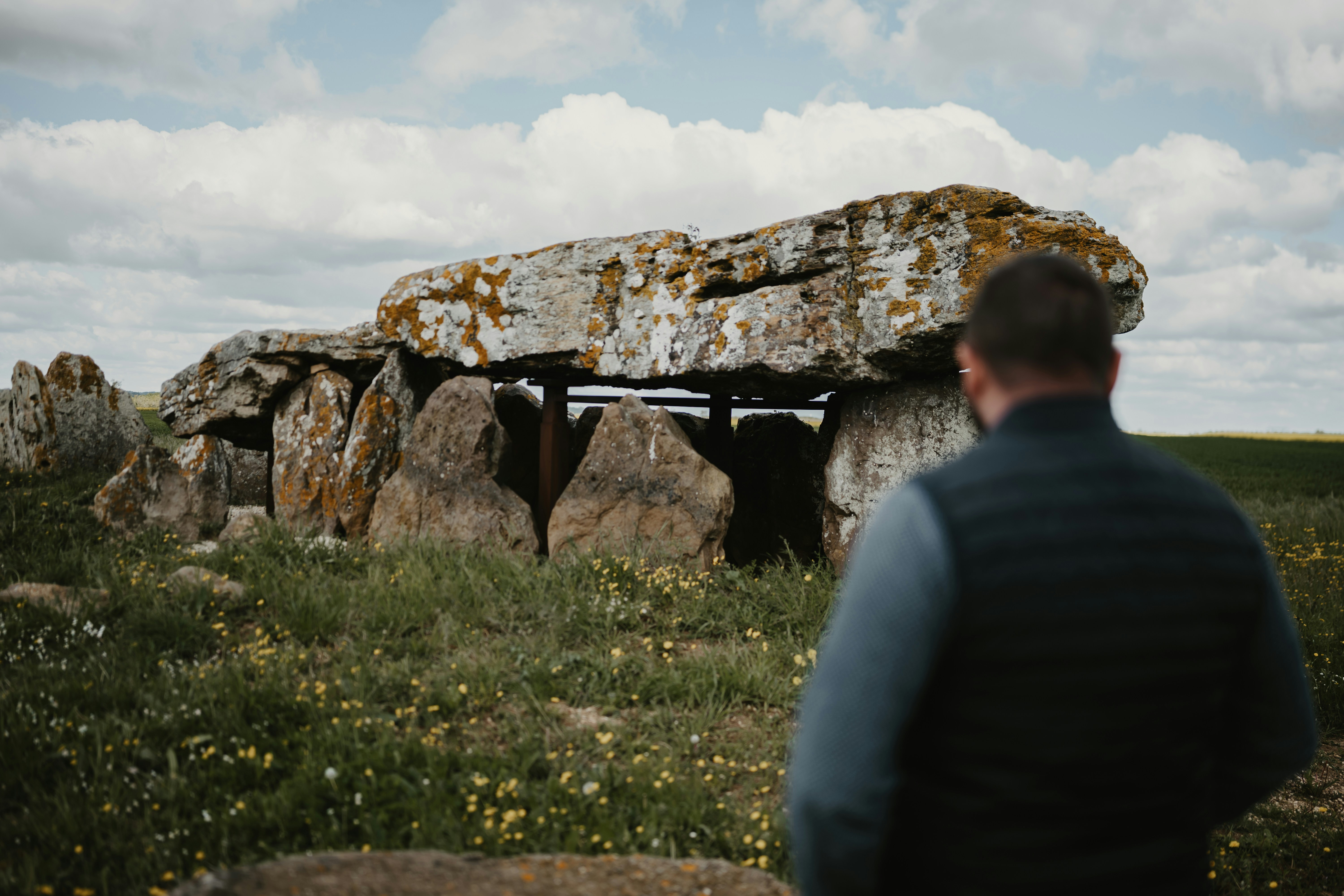 a man standing in front of a large rock formation