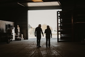a man and a woman walking into a garage