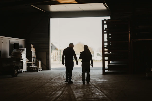 a man and a woman walking into a garage