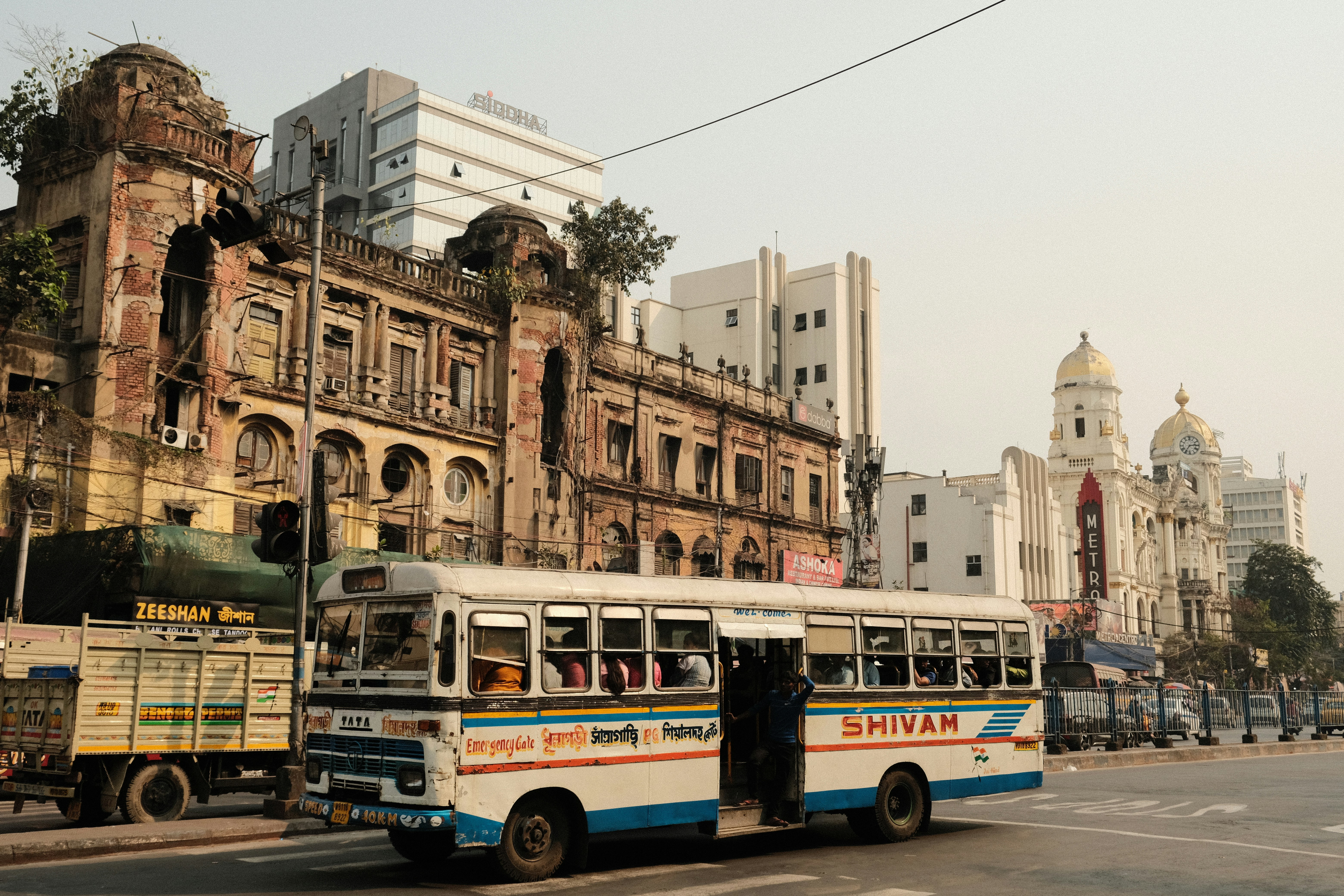 a bus driving down a street next to tall buildings