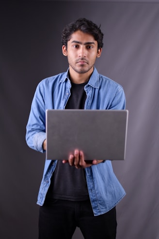 a man holding a laptop computer in his hands