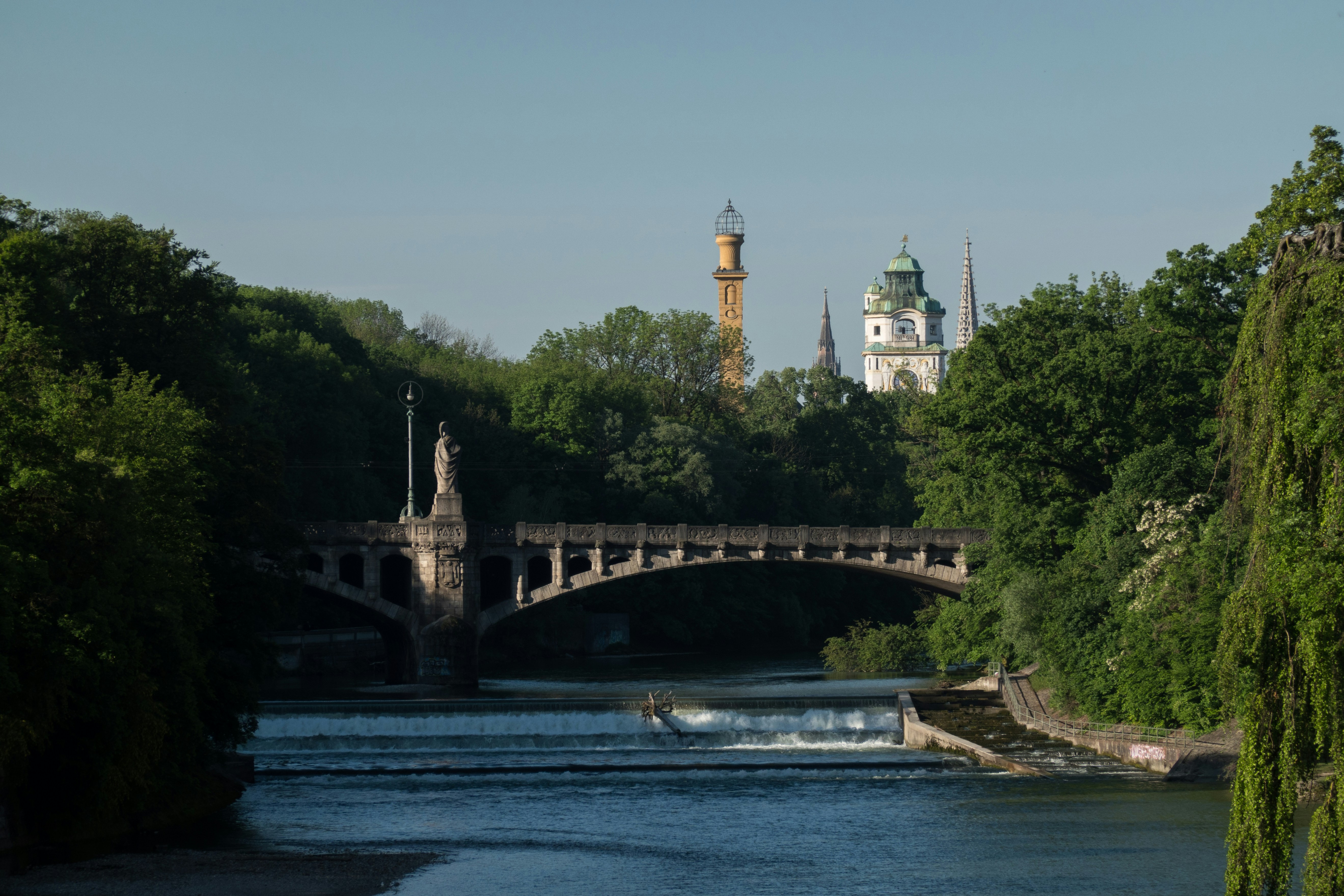 a bridge over a river with a castle in the background