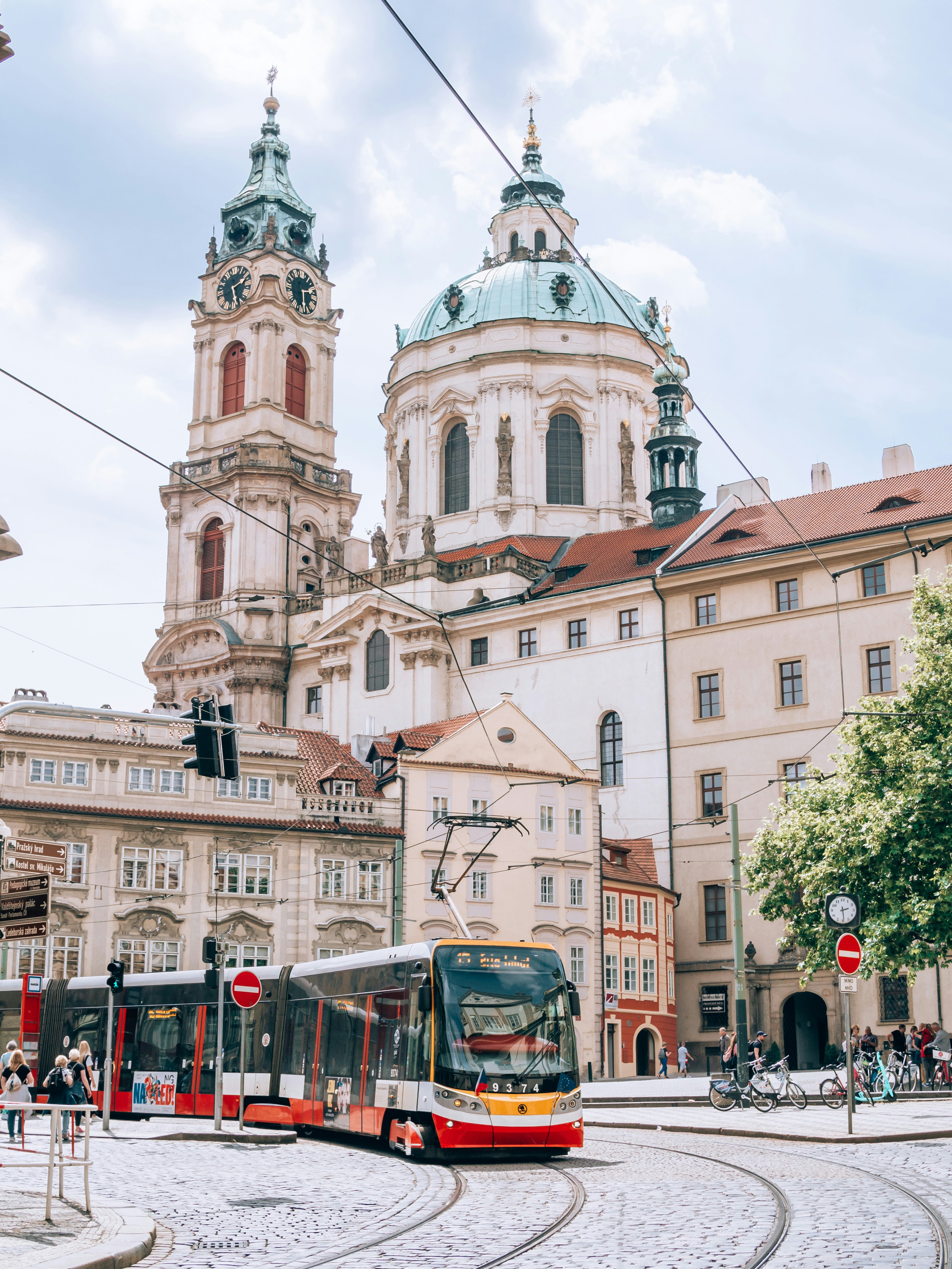 a red and white bus driving down a street next to tall buildings
