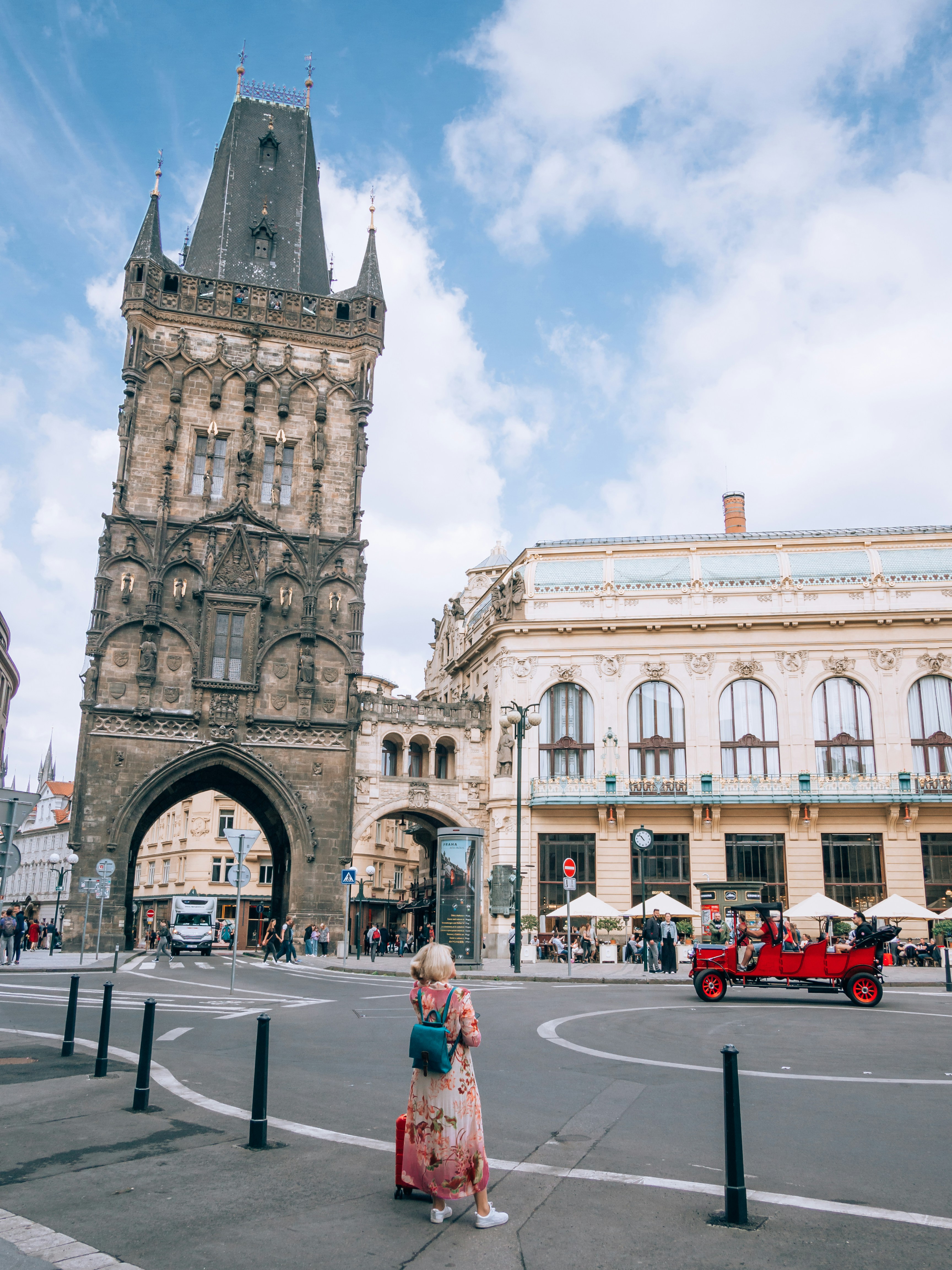 a woman walking down a street next to a tall building