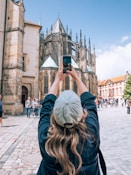 a woman taking a picture of a cathedral