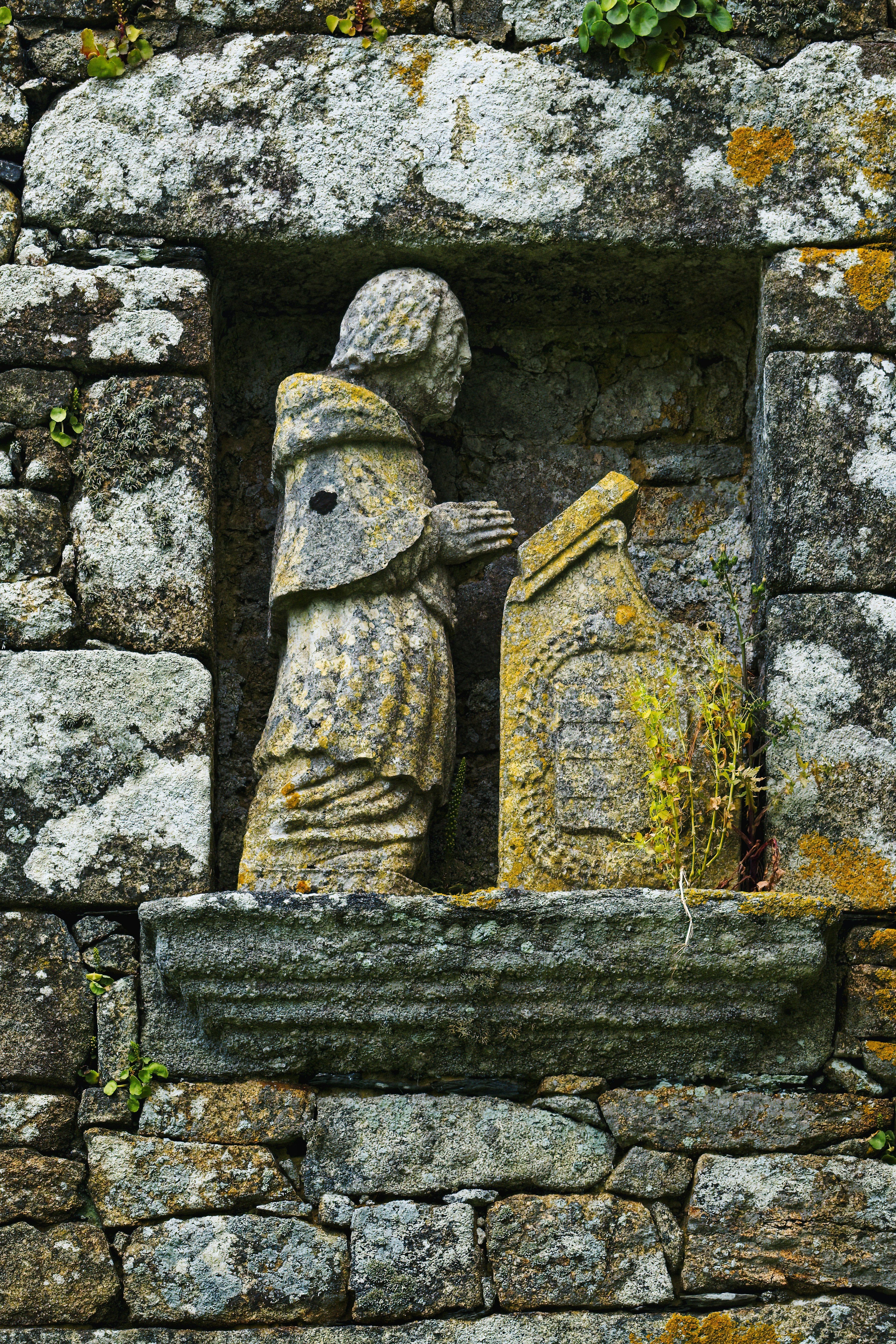 a stone statue of a man and a woman in a window