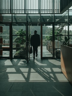 a man walking into a building with a suitcase