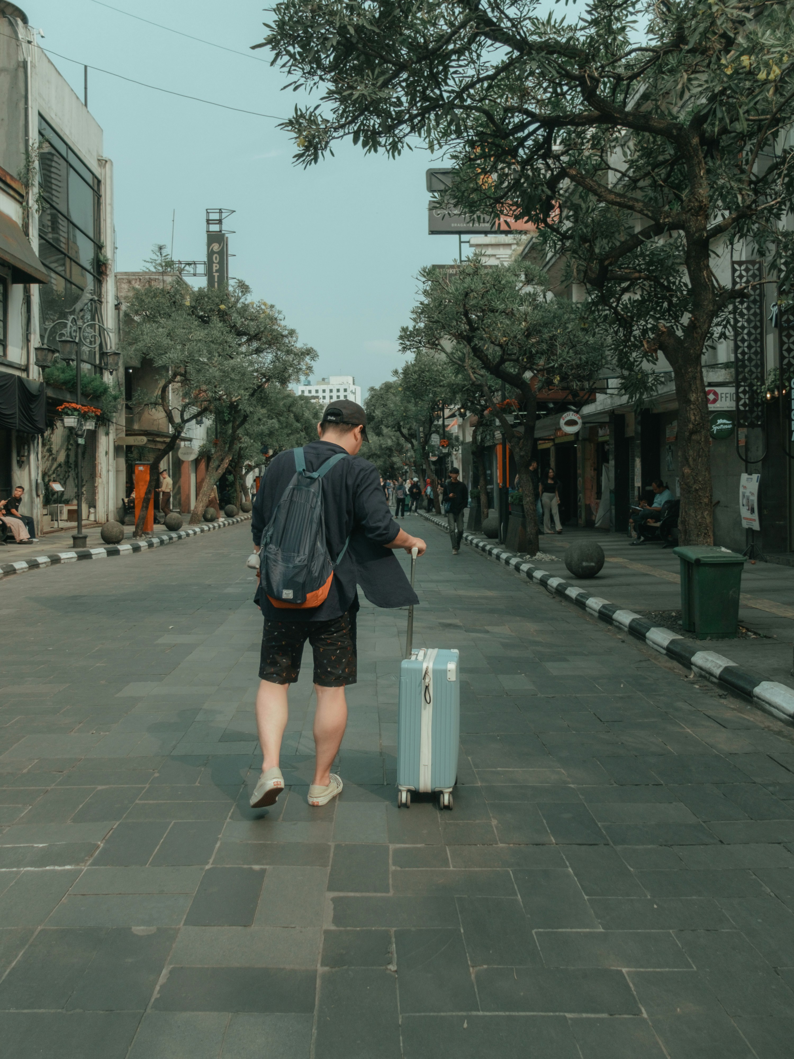 Un hombre caminando por una calle con una maleta