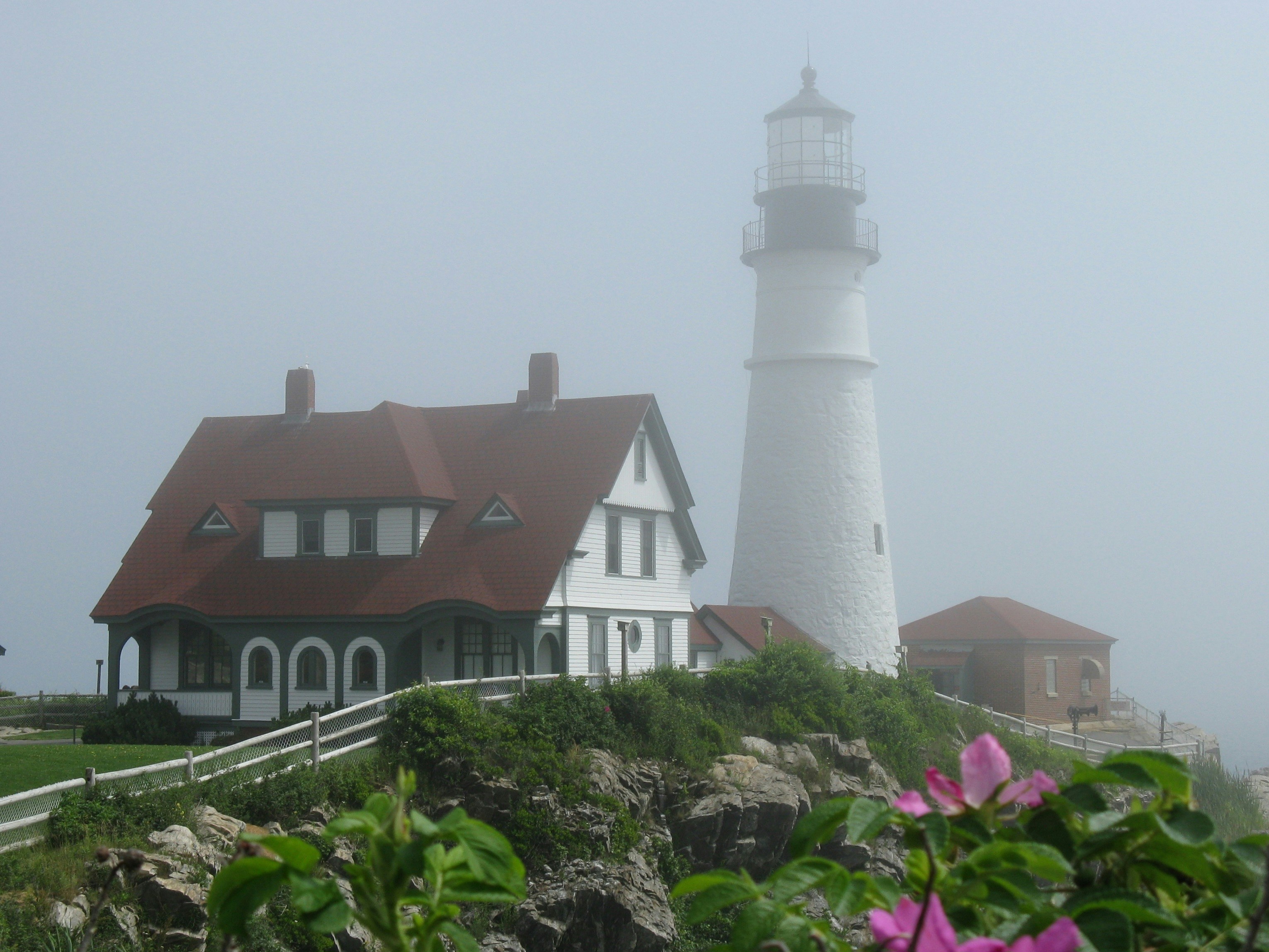 una casa bianca con un tetto rosso e una casa bianca