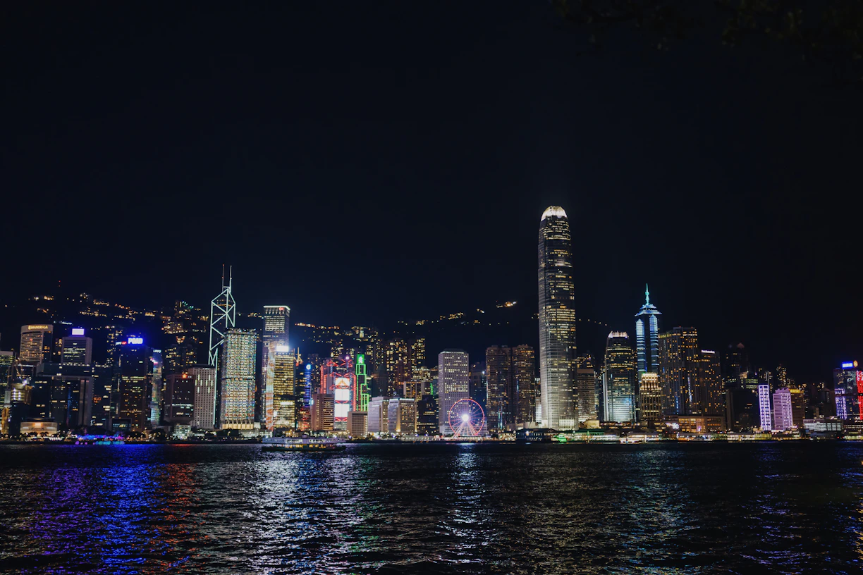 a city skyline at night with lights reflecting off the water