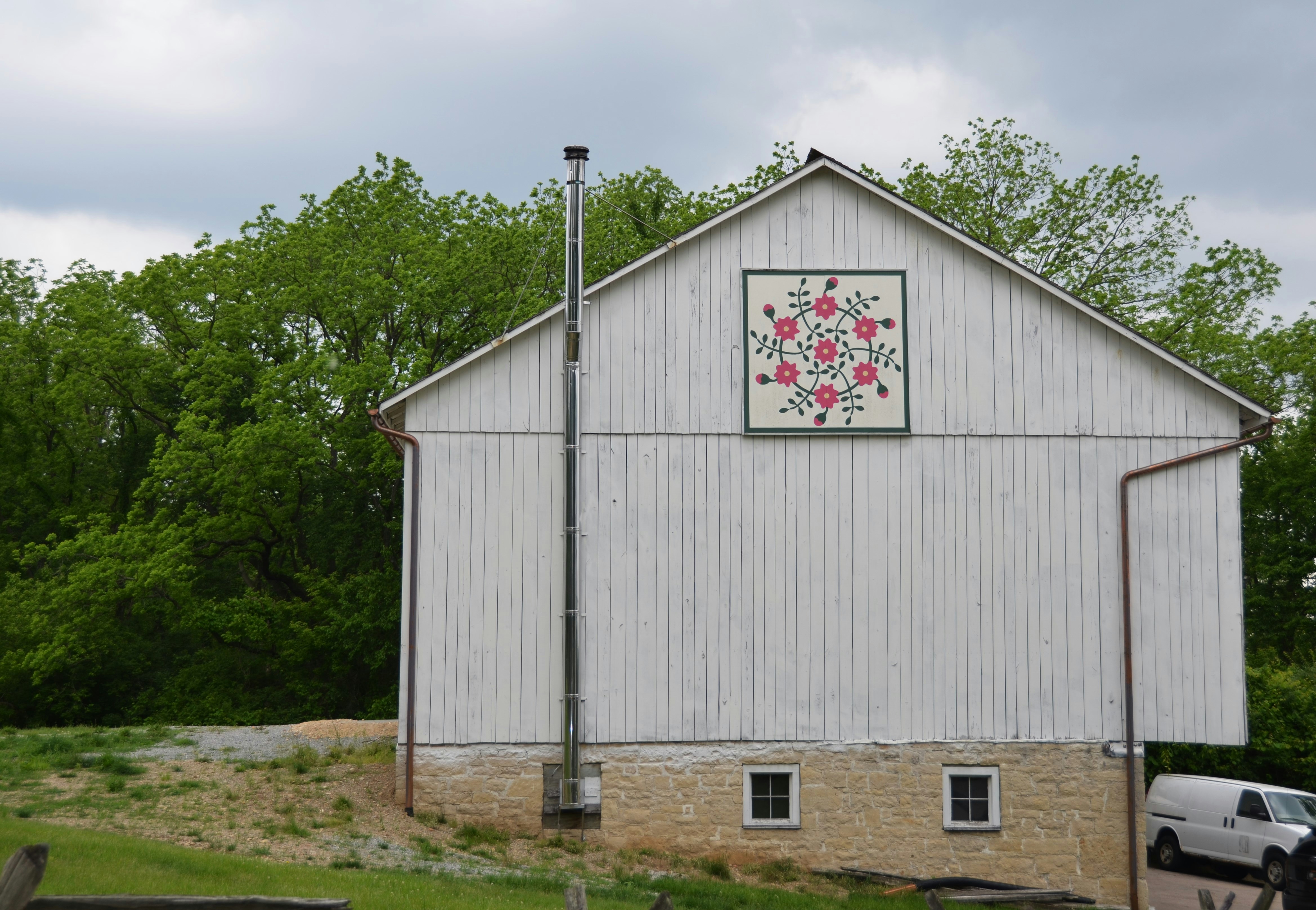 a white barn with a quilt on the side of it