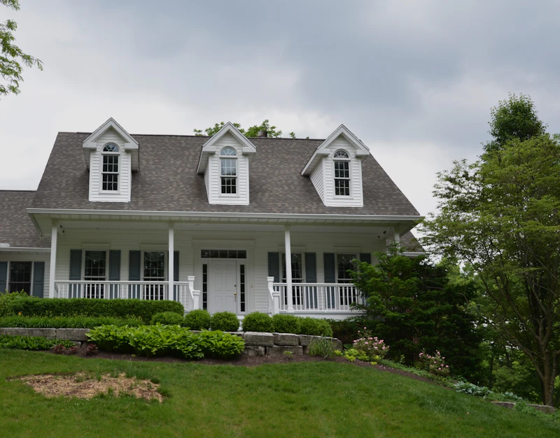 White farmhouse-style home with gray asphalt shingle roof