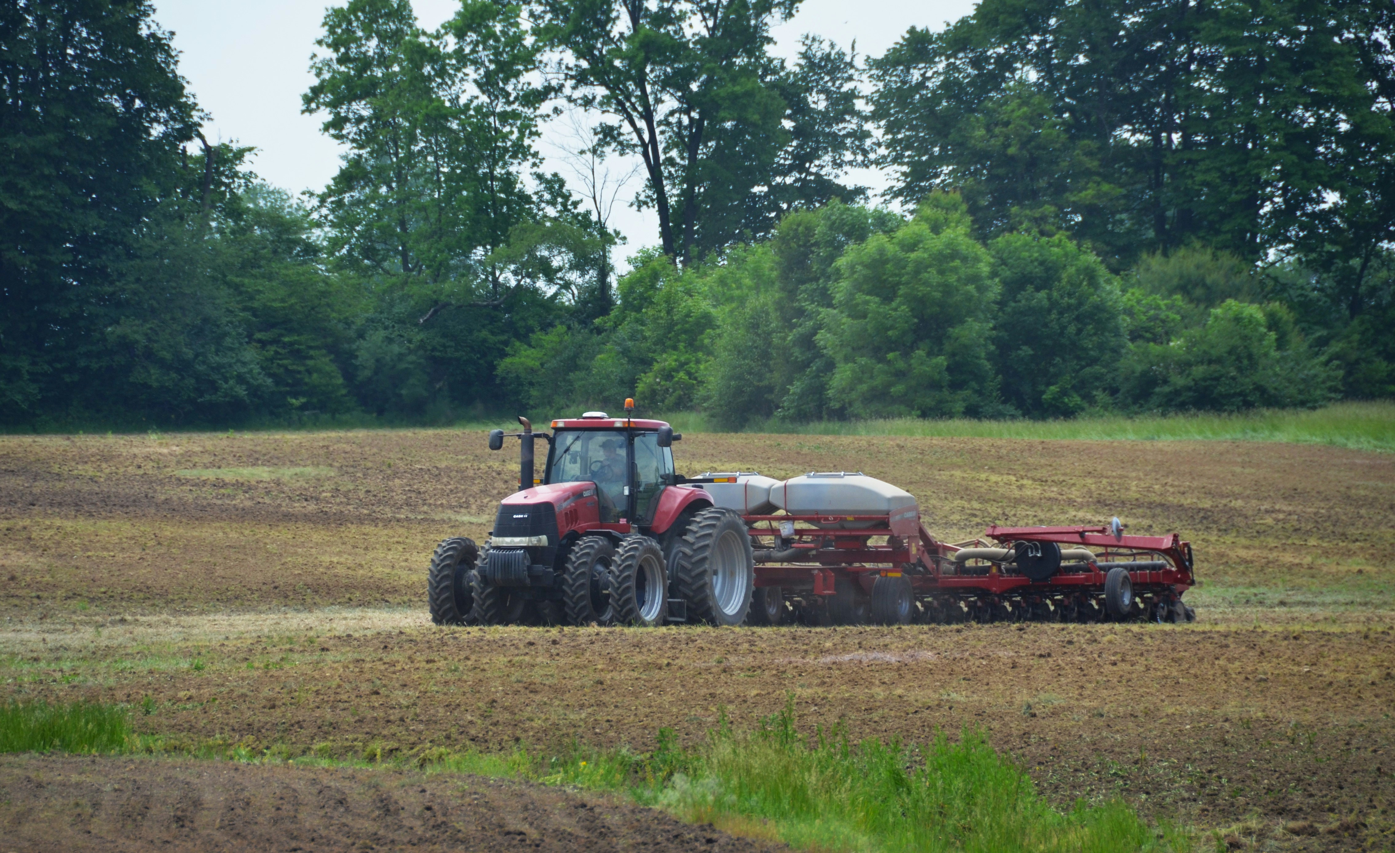 a tractor plowing a field with a sprayer