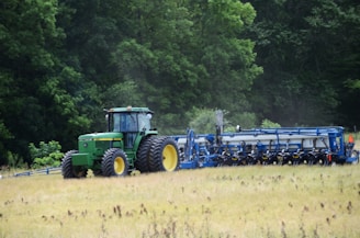a tractor is driving through a field of grass