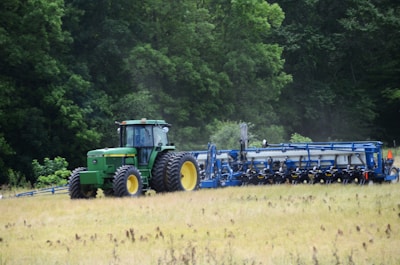 a tractor is driving through a field of grass