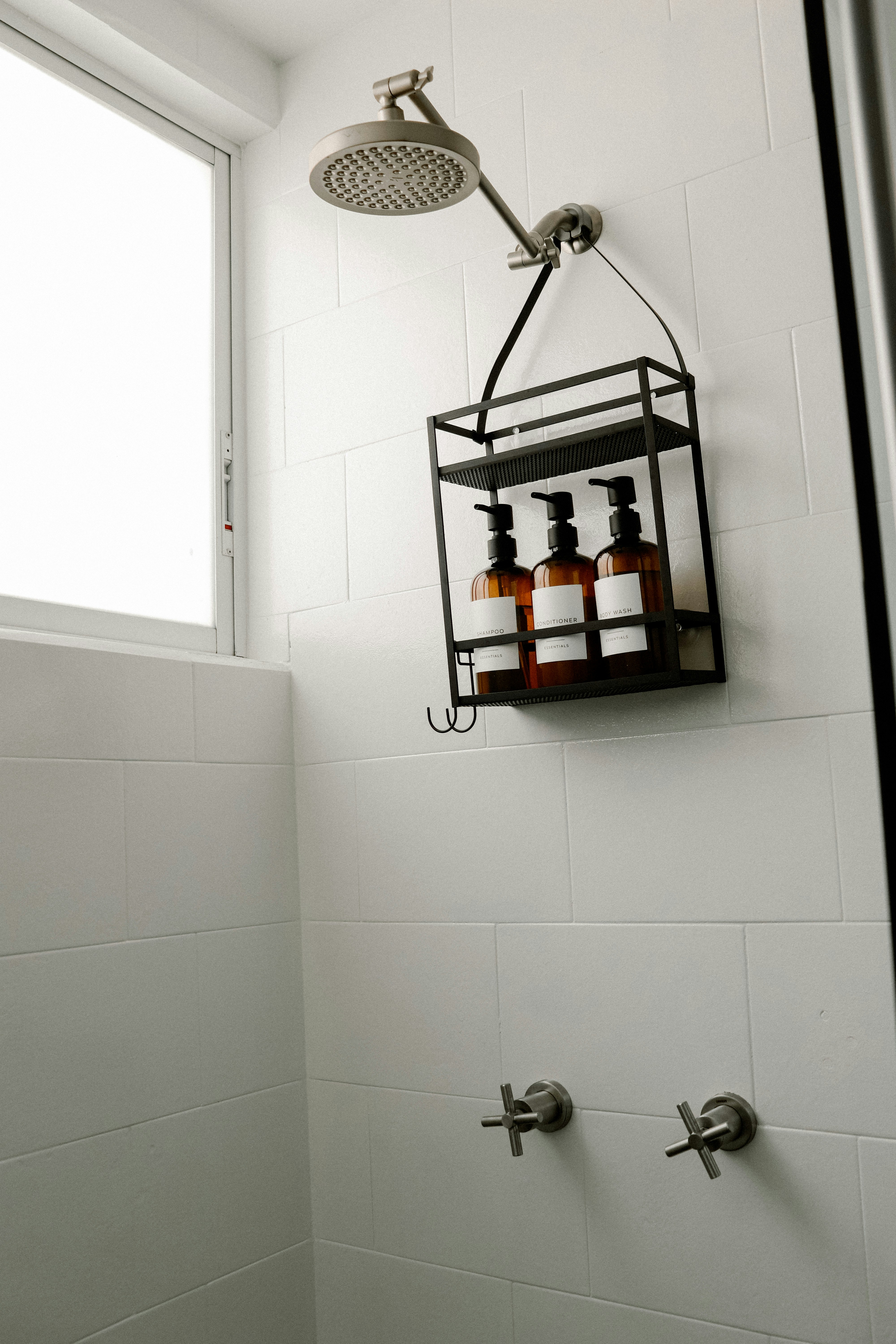 a bathroom with a shower head and soap dispenser