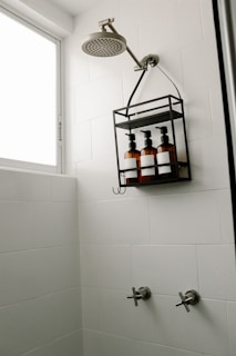 a bathroom with a shower head and soap dispenser