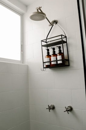a bathroom with a shower head and soap dispenser