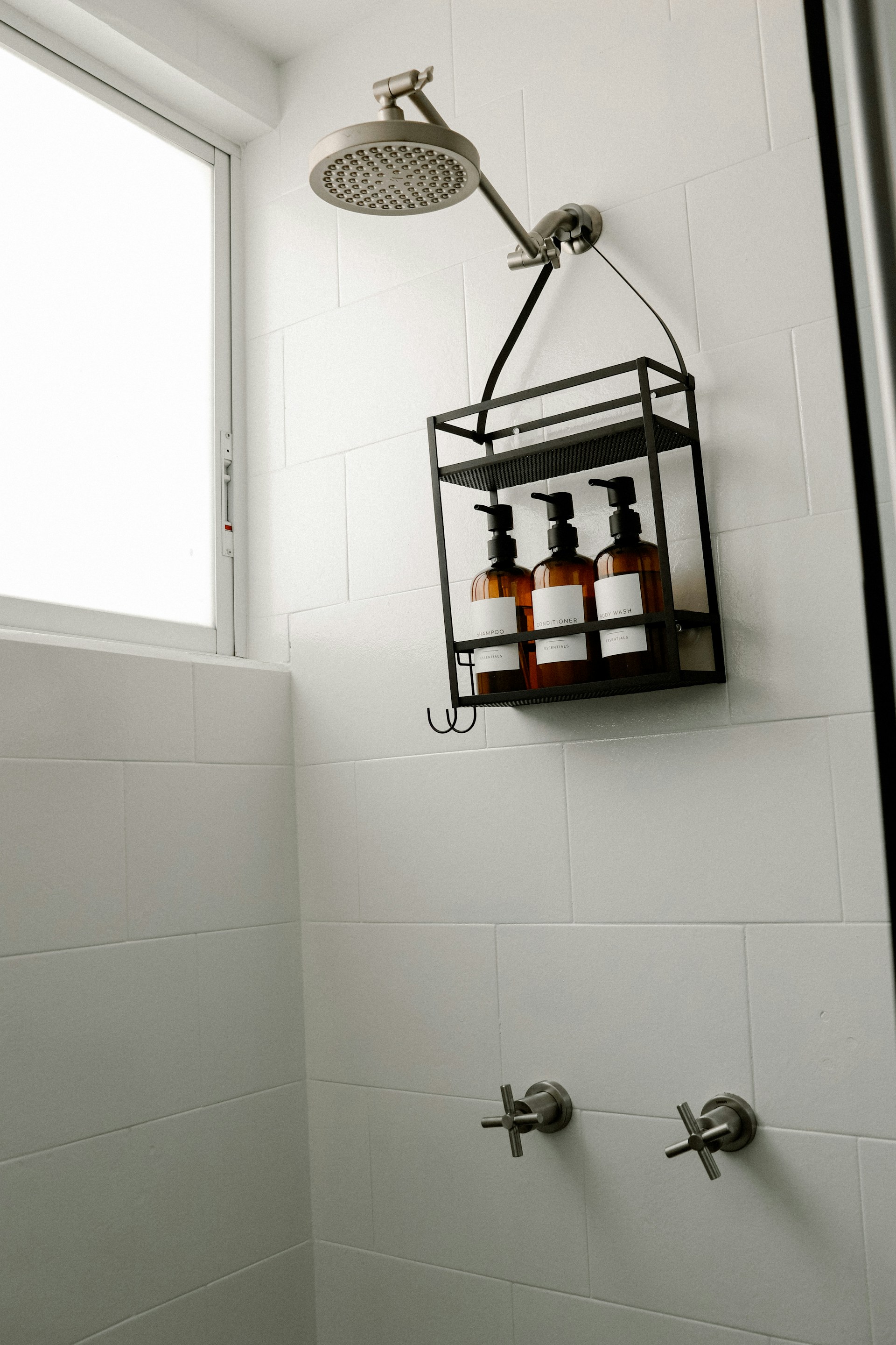 a bathroom with a shower head and soap dispenser