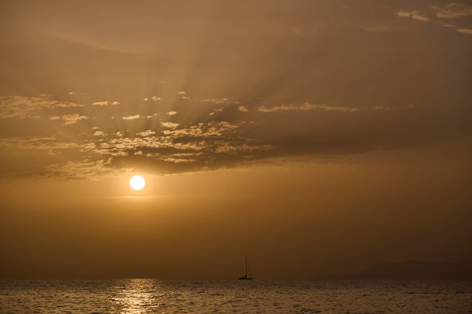 Serene sunset over the ocean with the sun setting behind the horizon slowly