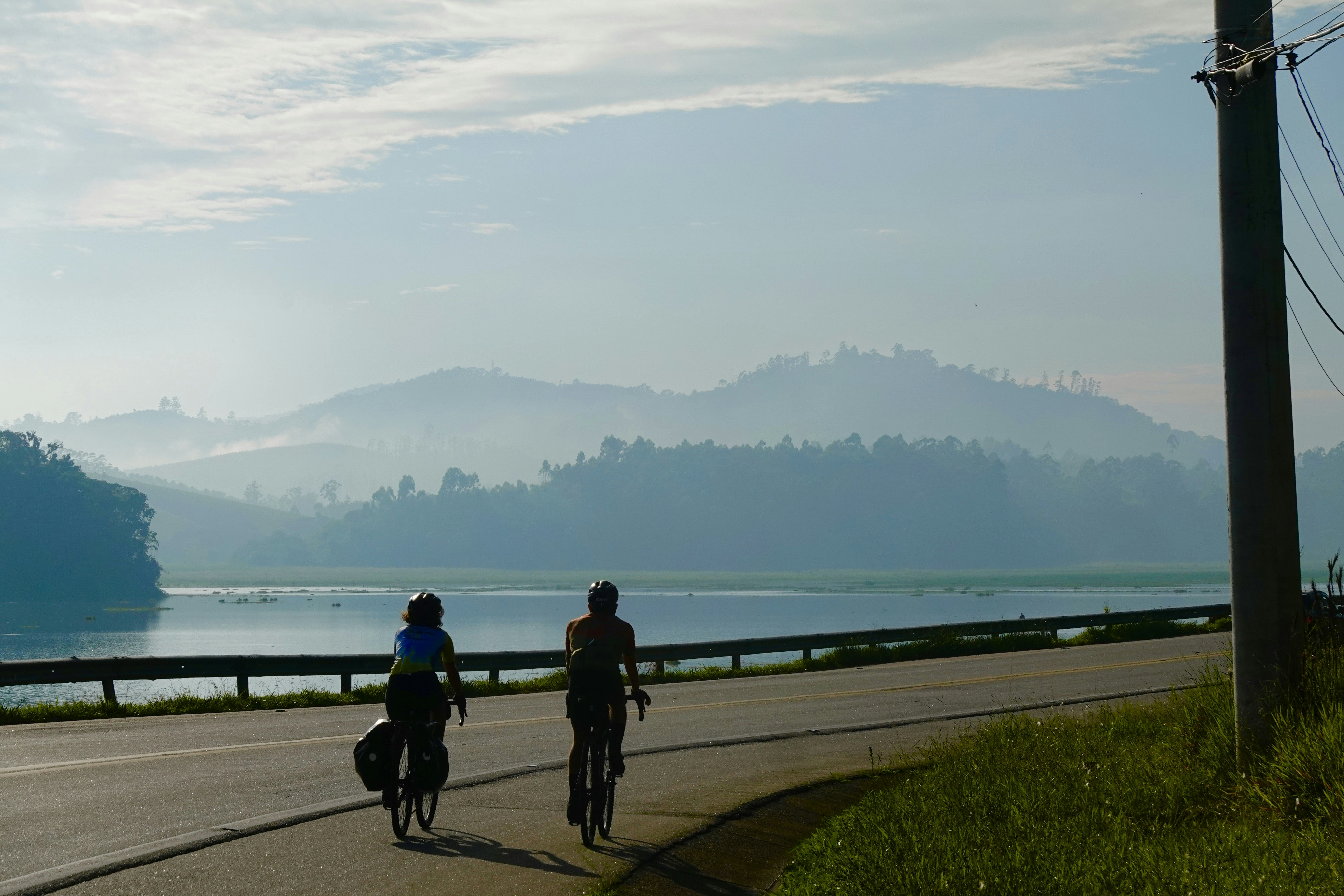 a couple of people riding bikes down a road, Casal numa manhã de Salesópolis