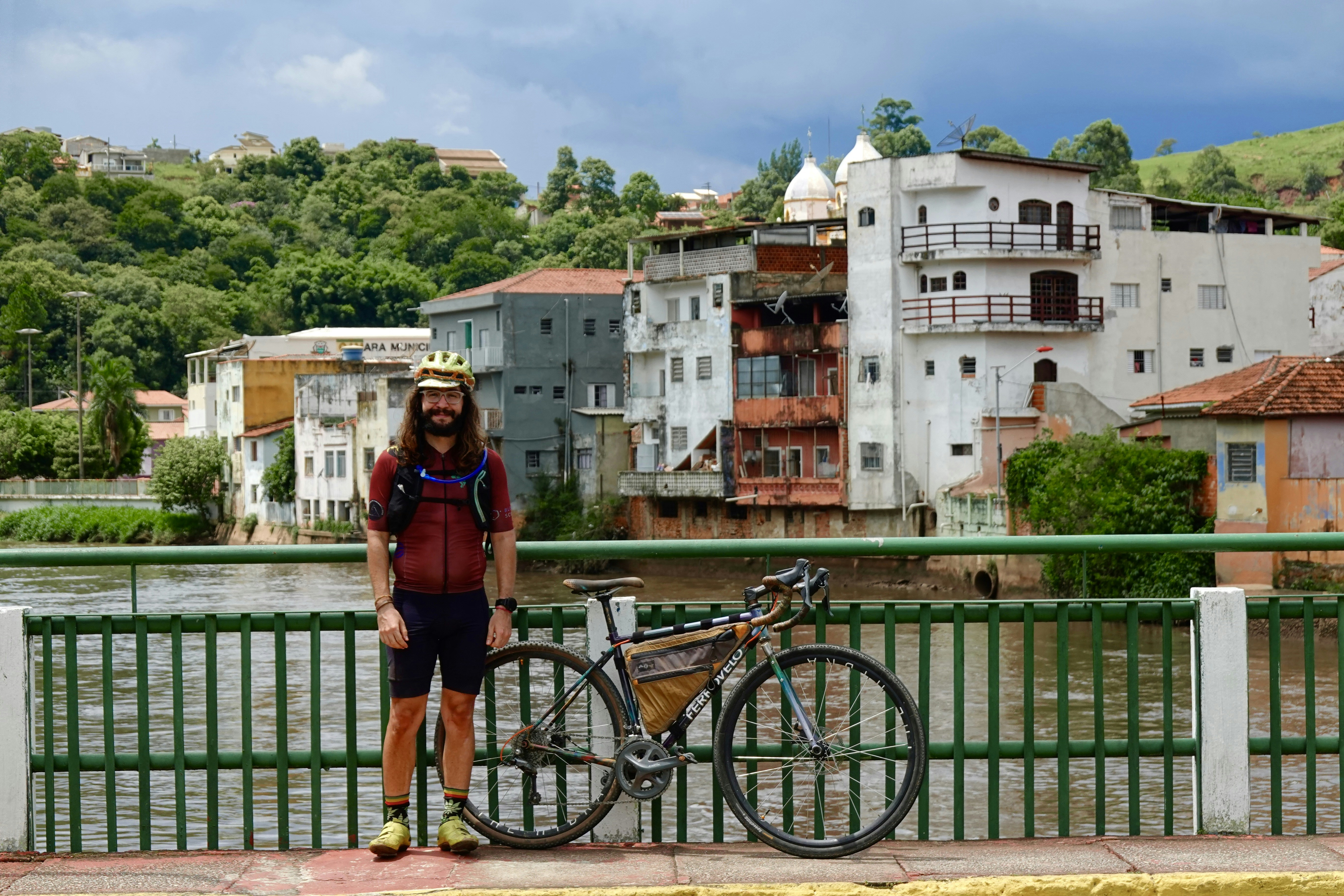 a man standing next to a bike next to a river