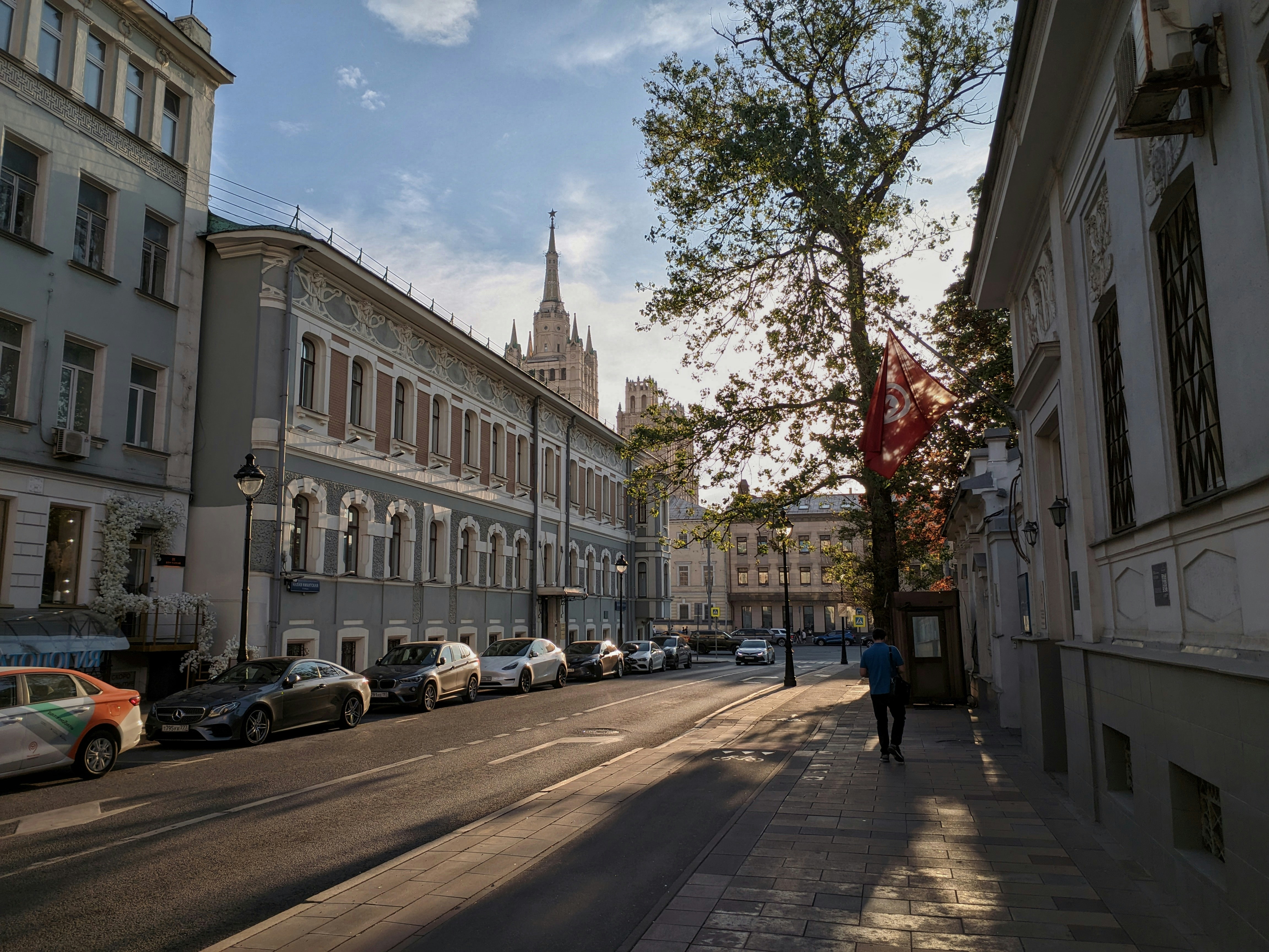 un uomo che cammina lungo una strada accanto a edifici alti
