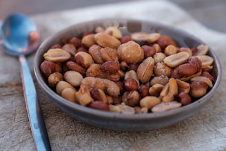 a bowl filled with nuts next to a spoon