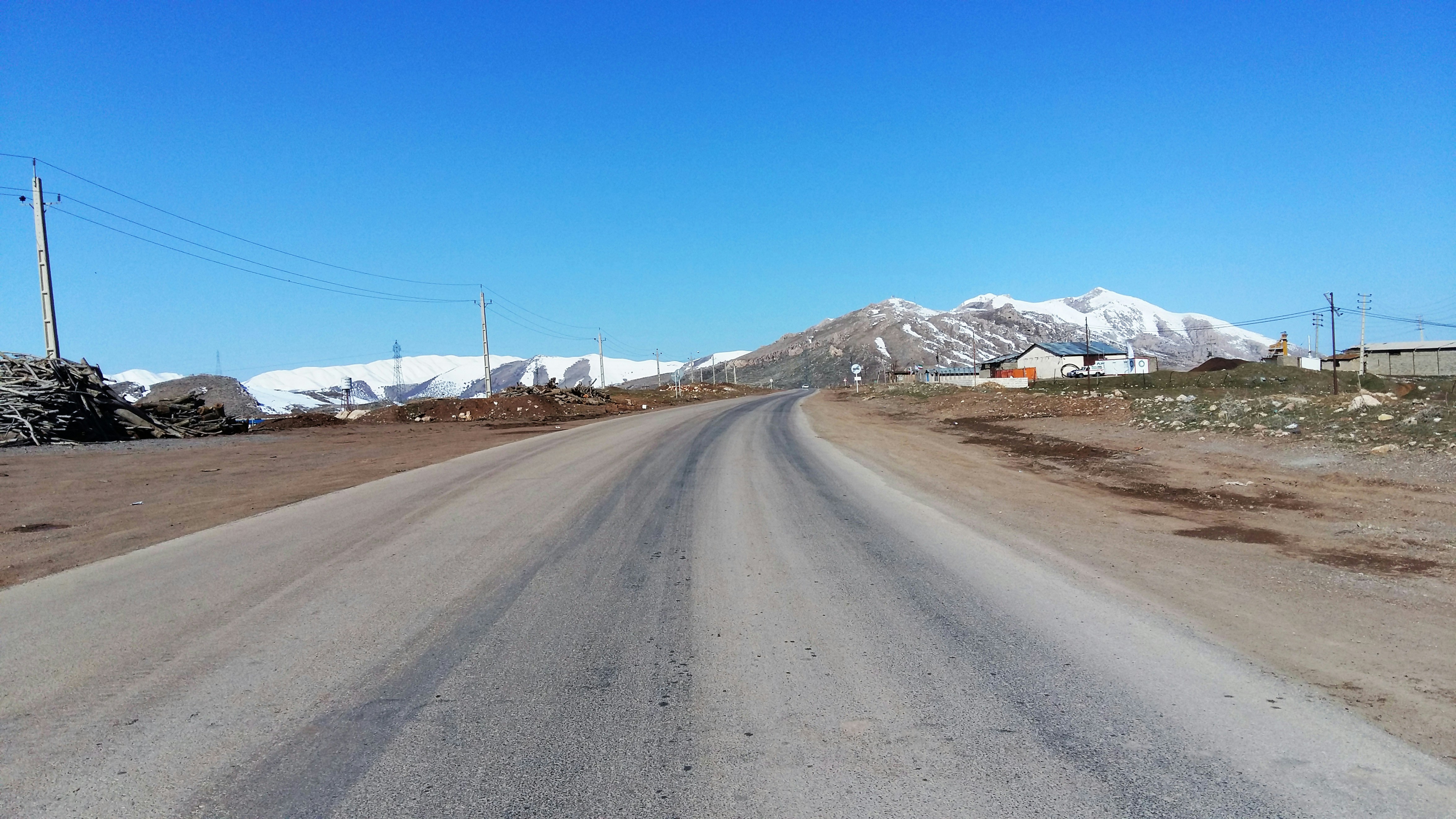 an empty road with mountains in the background