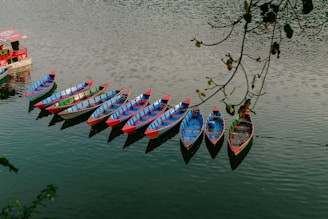a row of boats floating on top of a lake