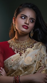 a woman wearing a red and gold sari
