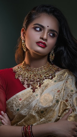 a woman wearing a red and gold sari