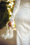 a woman in a white dress holding a white purse