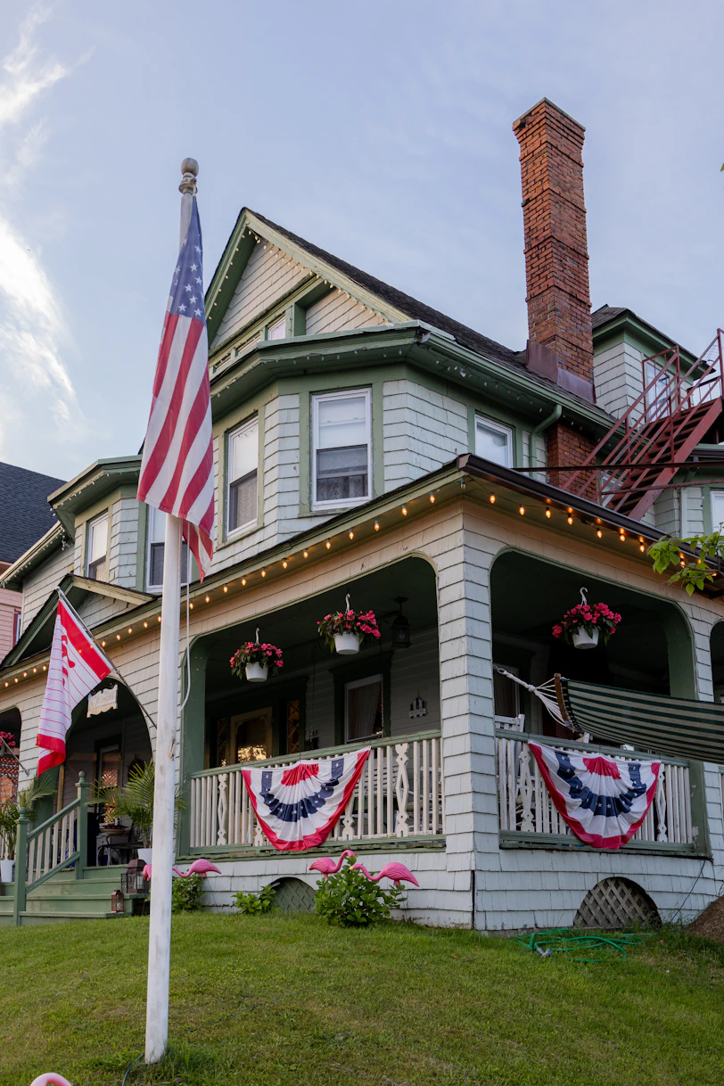 an american flag on a pole in front of a house