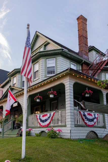 an american flag on a pole in front of a house