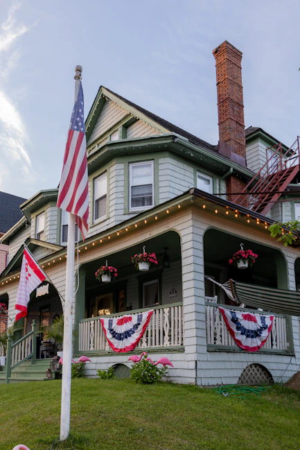 an american flag on a pole in front of a house