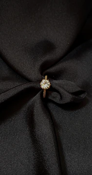 a close up of a black fabric with a ring on it