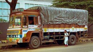 a man standing next to a truck with a tarp on it