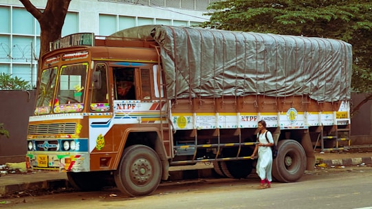 a man standing next to a truck with a tarp on it