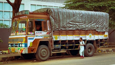 a man standing next to a truck with a tarp on it