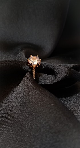a close up of a ring on a black fabric