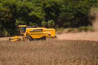 a yellow tractor is driving through a field