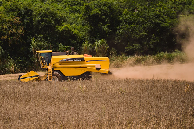 a yellow tractor is driving through a field